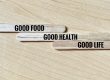 Wooden popsicle sticks with written phrase Good Food, Good Health, and Good Life.