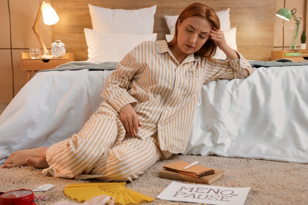 Mature woman experiencing menopause in bedroom at night